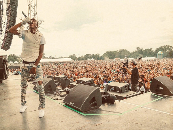 A crowd raves at an outdoor concert.